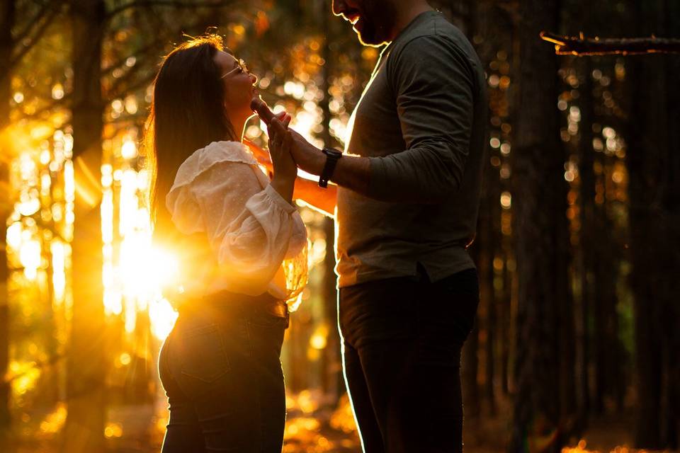 Pareja posando en el atardecer de un bosque